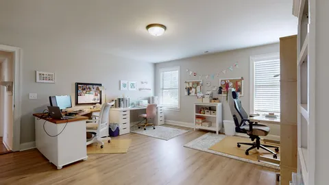 a view of a workspace with furniture and a window