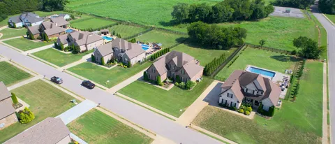 an aerial view of a golf course with swimming pool and outdoor seating