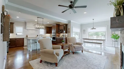 a living room with furniture wooden floor and a large window