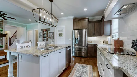 a kitchen with stainless steel appliances granite countertop a sink refrigerator and cabinets