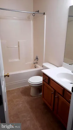 a bathroom with a granite countertop sink toilet a mirror and shower