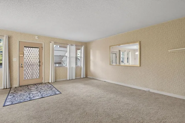 a view of an empty room with closet and a window