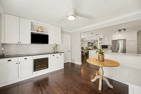 a kitchen with a table chairs microwave and cabinets