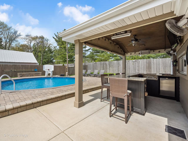 3S171 Arboretum Road Glen Ellyn, IL 60137 - Photo 32 of 41 a view of a patio with a table and chairs under an umbrella with a small yard