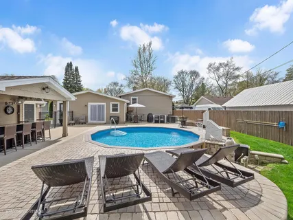 a view of a house with pool and chairs