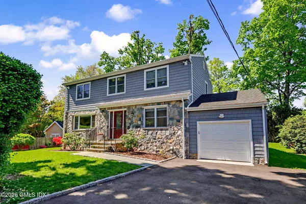 a front view of a house with a yard and potted plants