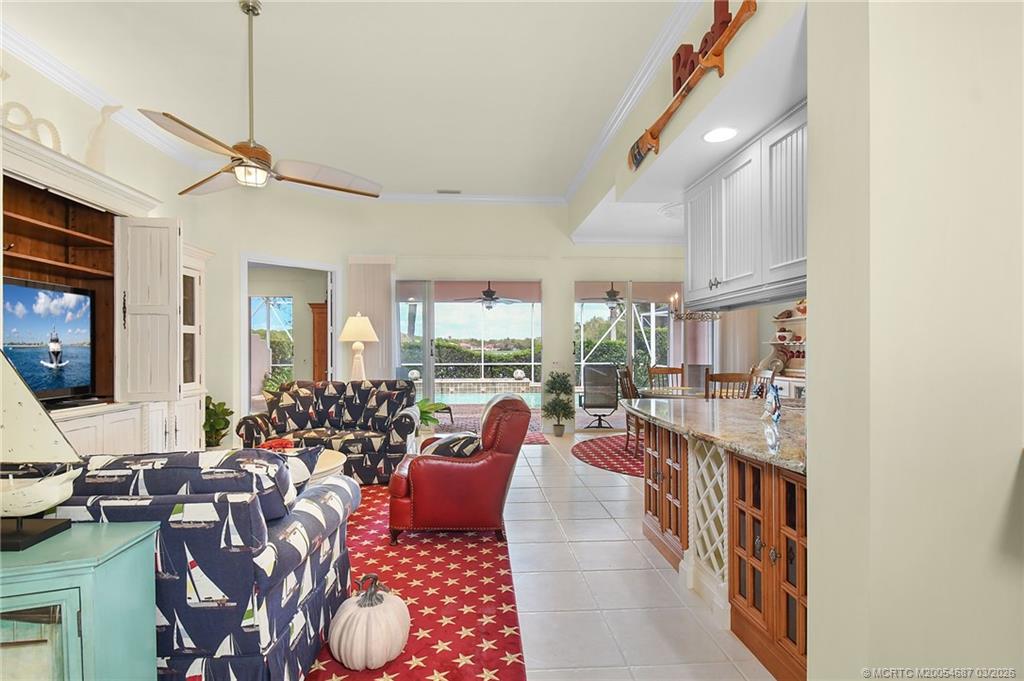 1541 Southwest Balmoral Trace Stuart, FL 34997 - Photo 11 of 52 a living room with lots of furniture and a chandelier