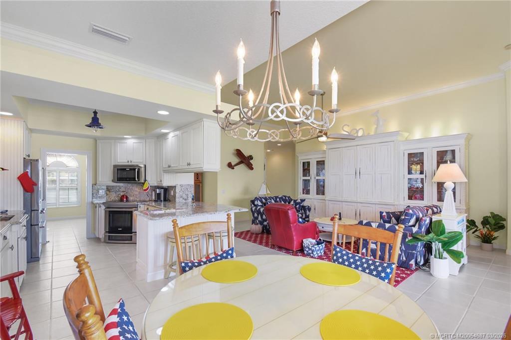 1541 Southwest Balmoral Trace Stuart, FL 34997 - Photo 20 of 52 a living room with furniture kitchen view and a chandelier