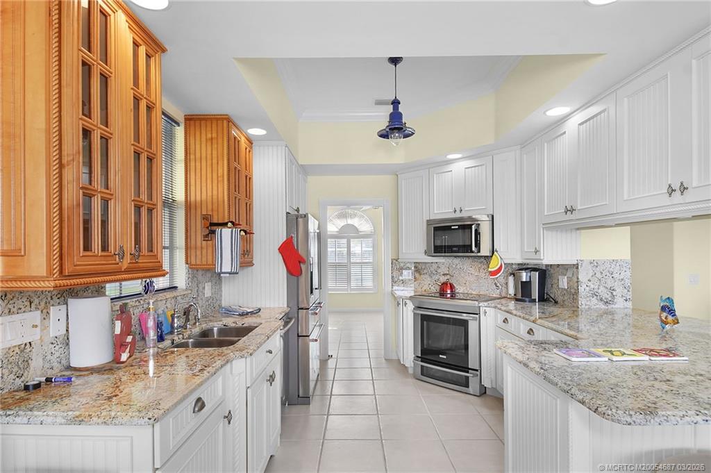 1541 Southwest Balmoral Trace Stuart, FL 34997 - Photo 21 of 52 a kitchen with stainless steel appliances granite countertop a sink stove and refrigerator
