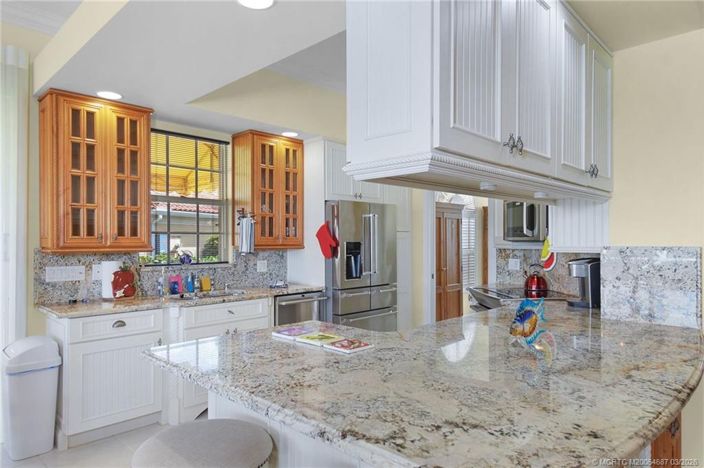 1541 Southwest Balmoral Trace Stuart, FL 34997 - Photo 22 of 52 a kitchen with stainless steel appliances granite countertop a sink and cabinets