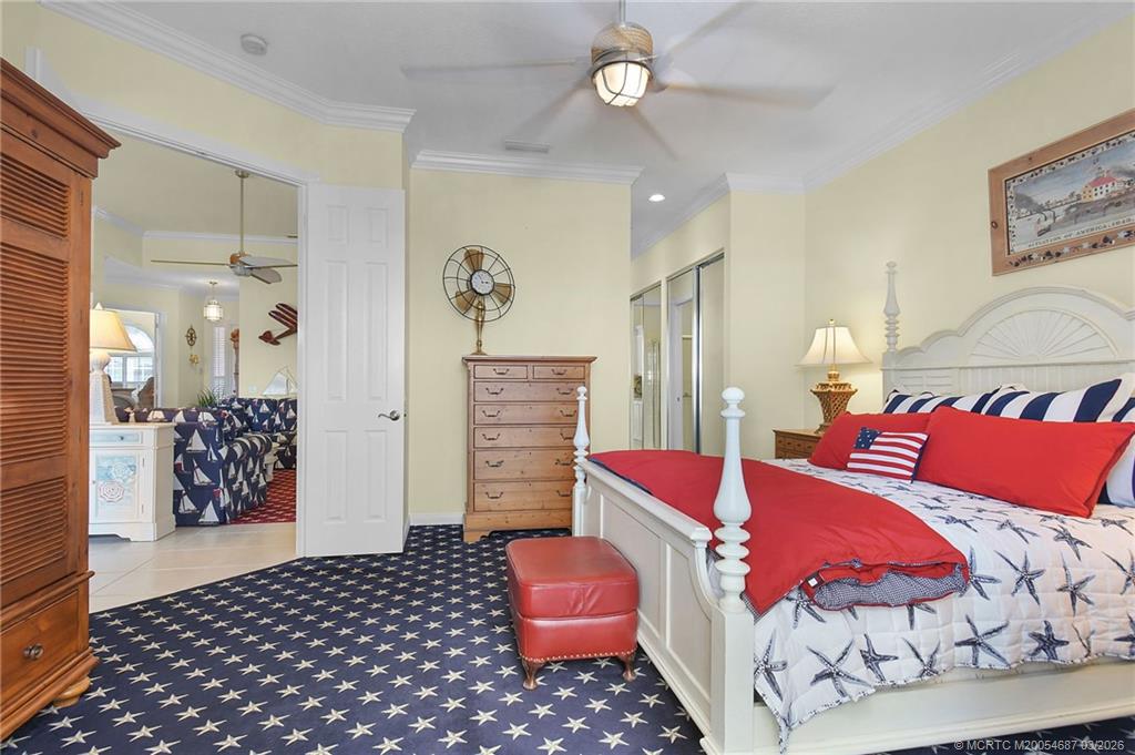 1541 Southwest Balmoral Trace Stuart, FL 34997 - Photo 32 of 52 a bedroom with a bed and a chair with the bookshelf