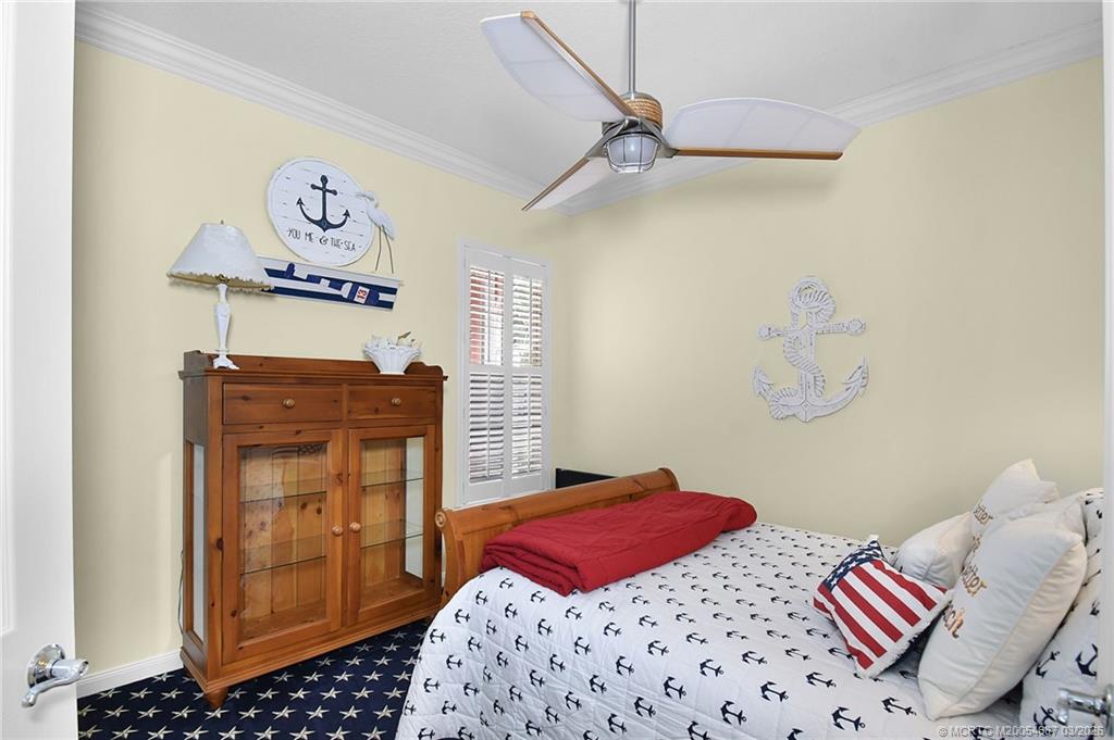 1541 Southwest Balmoral Trace Stuart, FL 34997 - Photo 39 of 52 a bedroom with a bed and cabinets