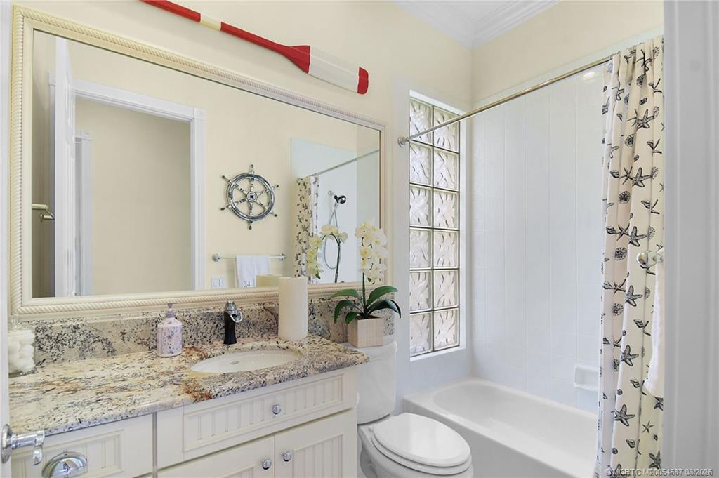 1541 Southwest Balmoral Trace Stuart, FL 34997 - Photo 40 of 52 a bathroom with a granite countertop sink a toilet and shower