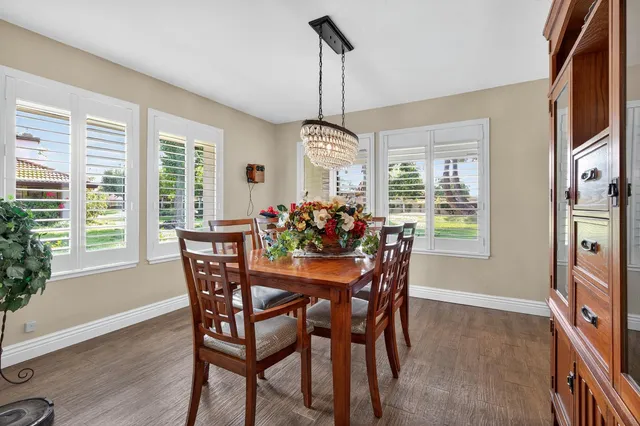 a dining room with furniture a chandelier and wooden floor