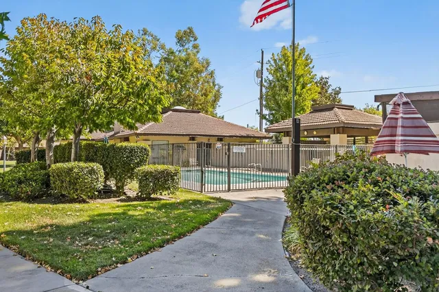 a front view of a house with a yard and potted plants