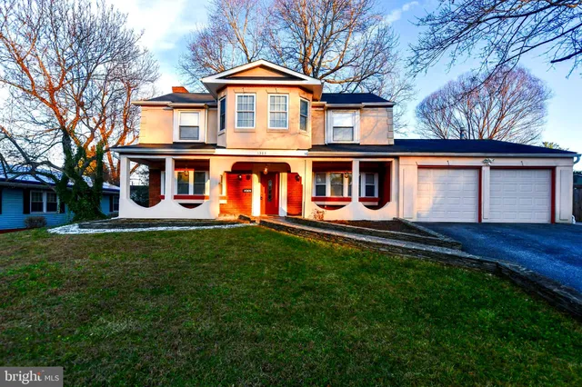 a front view of a house with yard and green space
