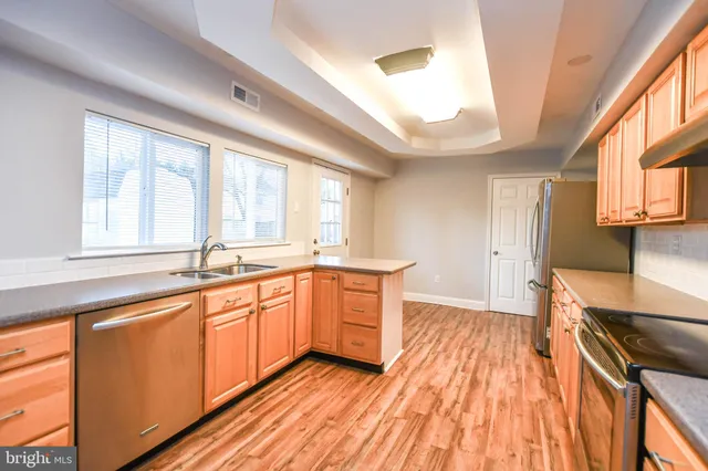 a kitchen with granite countertop wooden floors a stove and a window