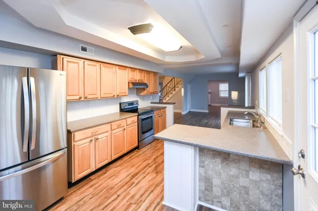 wooden floor fireplace and windows in an empty room