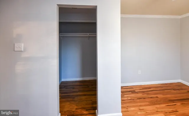 a kitchen with stainless steel appliances granite countertop a refrigerator a sink dishwasher a stove and white countertops with wooden floor