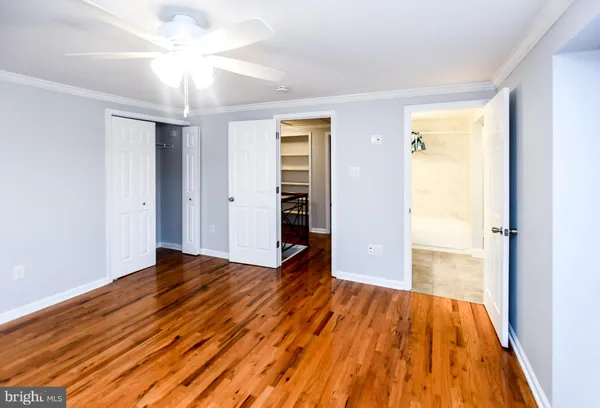 a view of an empty room with wooden floor fireplace and a window