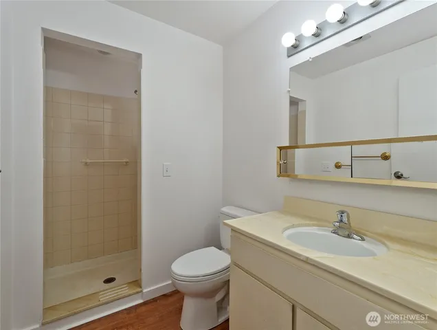 a bathroom with a sink a toilet and shower