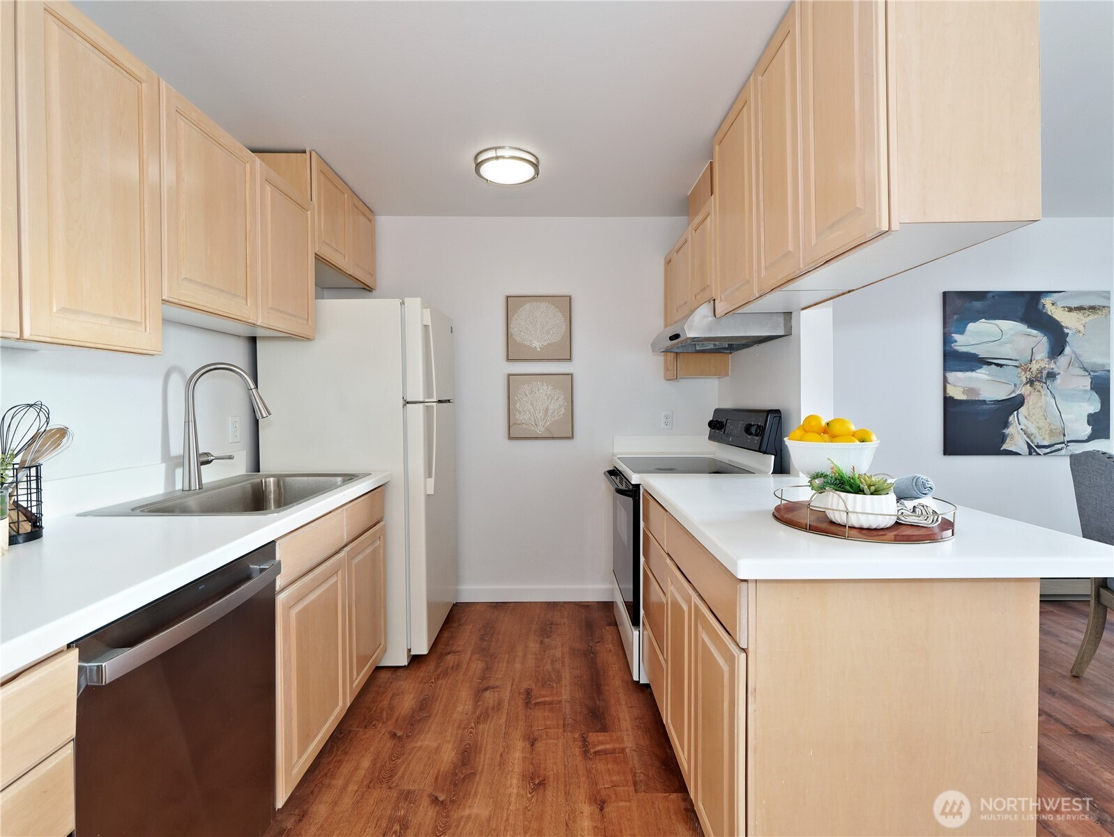 2104 Alki Avenue Southwest, Unit 205 Seattle, WA 98116 - Photo 5 of 39 a kitchen with stainless steel appliances granite countertop a sink and dishwasher a stove top oven with wooden floor