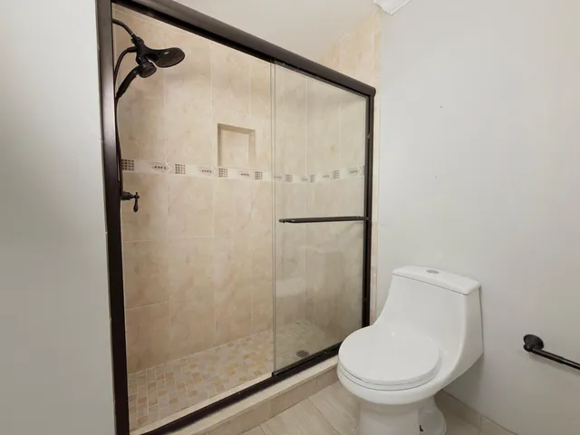 a bathroom with a toilet and a shower