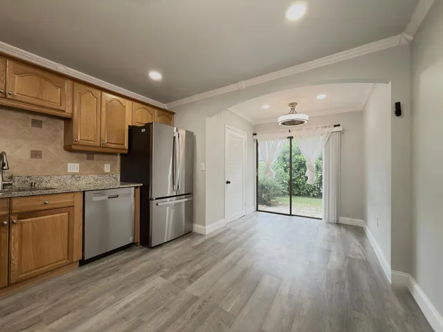 a kitchen with a refrigerator a stove top oven a sink and dishwasher with wooden floor