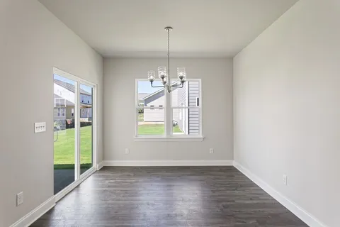 a view of a room with window wooden floor and front door