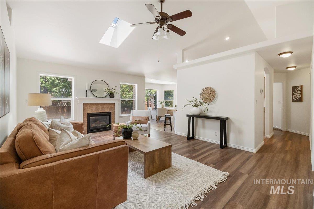 2032 Talus Loop Twin Falls, ID 83301 - Photo 10 of 43 Spacious living area featuring high vaulted ceilings, skylight, wood-finish flooring, a tiled fireplace, and multiple windows
