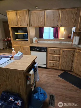 a kitchen with a sink cabinets and wooden floor