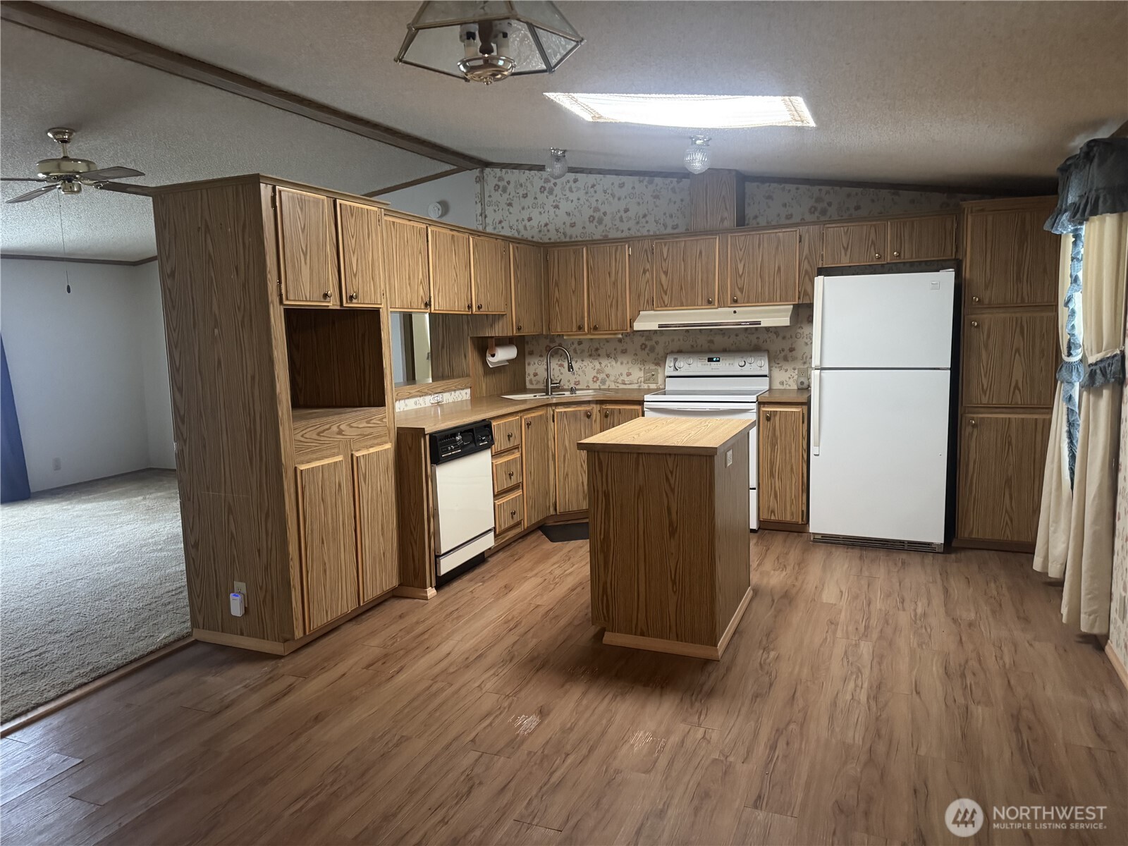212 Old Owen Road, Unit 59 Sultan, WA 98294 - Photo 4 of 13 a kitchen with kitchen island wooden floors appliances and cabinets