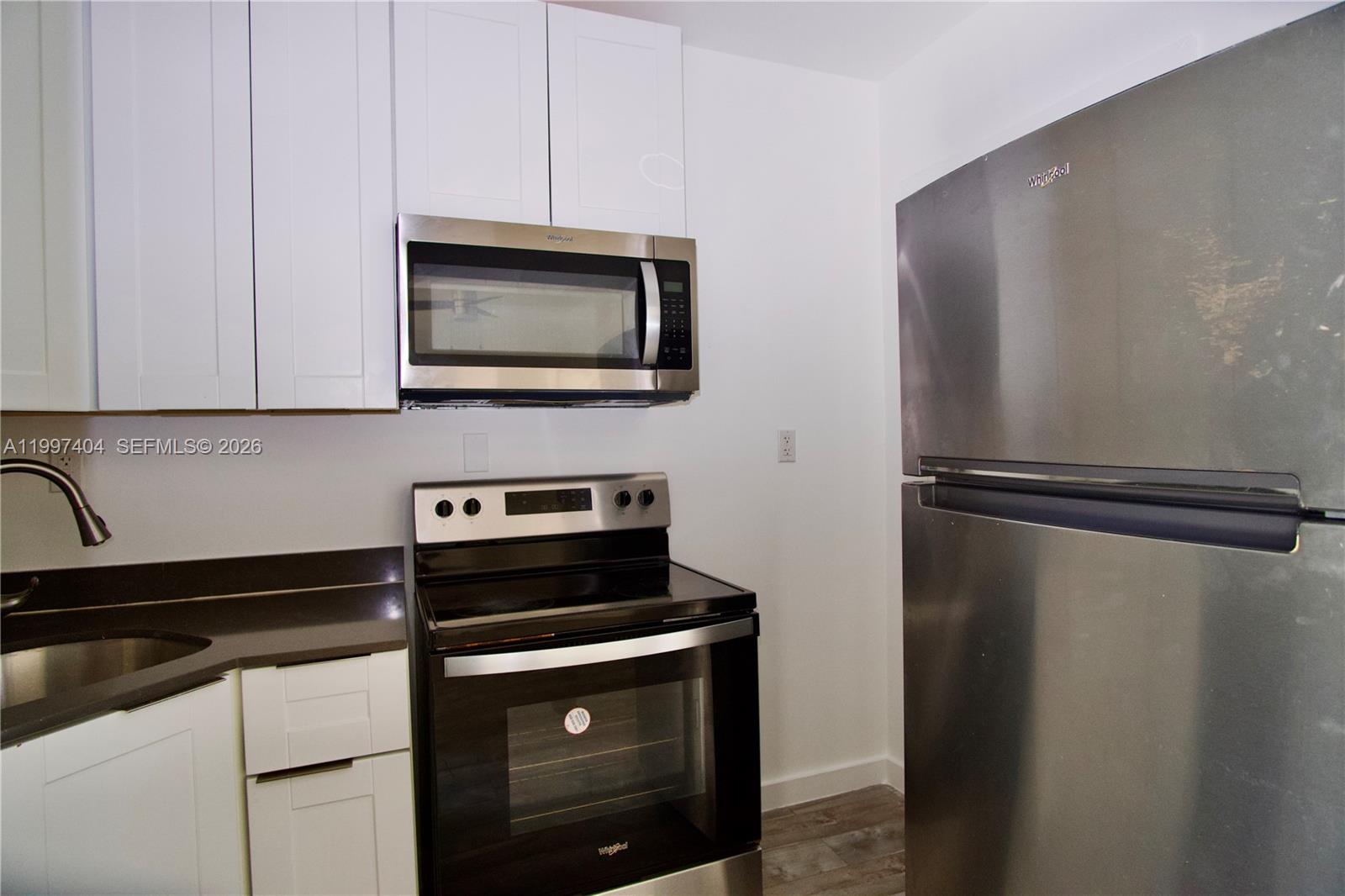 1036 Southwest 5th Street, Unit 12 Miami, FL 33130 - Photo 12 of 19 a kitchen with cabinets and stainless steel appliances