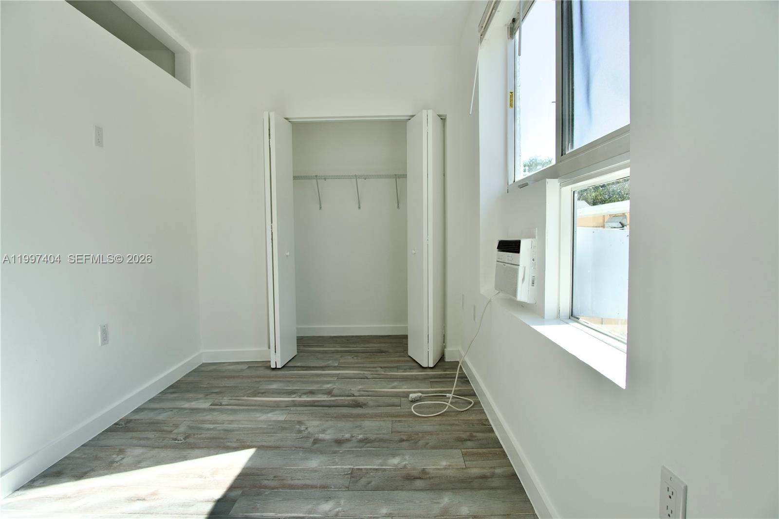 1036 Southwest 5th Street, Unit 12 Miami, FL 33130 - Photo 2 of 19 a view of a hallway with wooden floor and a bathroom