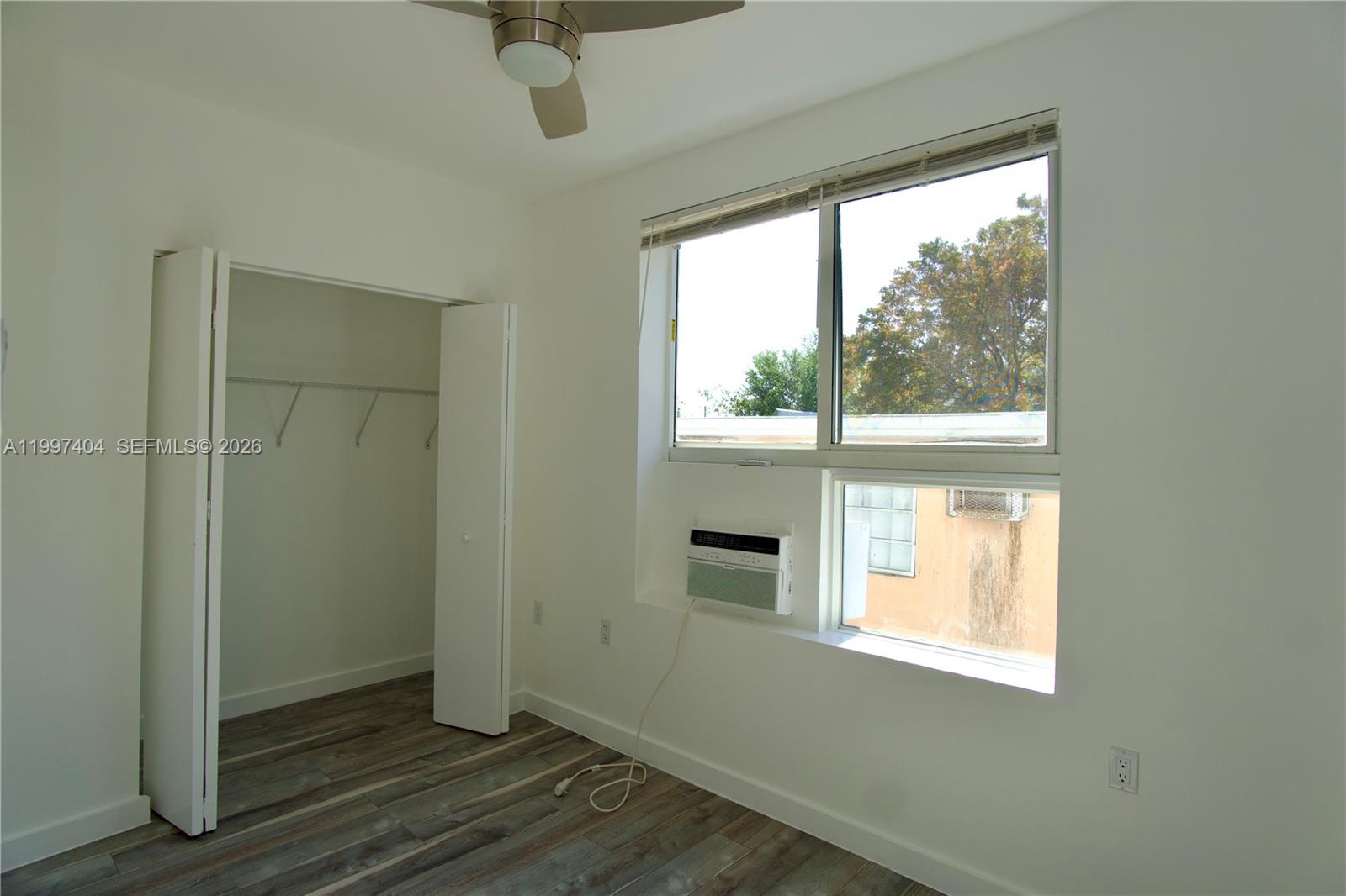1036 Southwest 5th Street, Unit 12 Miami, FL 33130 - Photo 3 of 19 an empty room with wooden floor and windows