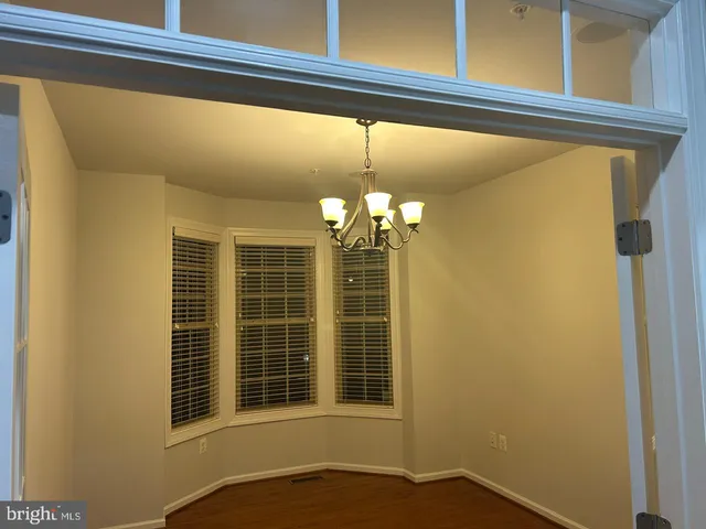 a view of a hallway with windows and chandelier