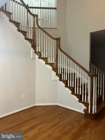 a view of a hallway with wooden floor and stairs