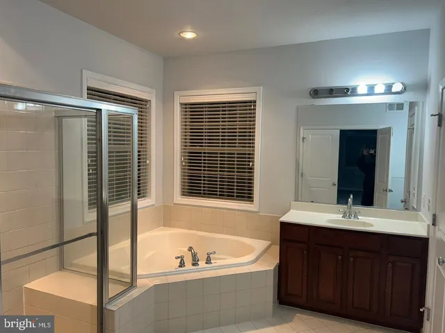 a bathroom with a tub sink and mirror