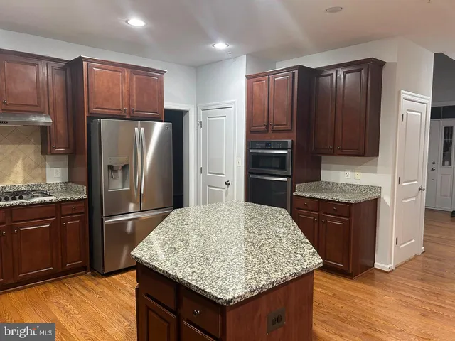a kitchen with stainless steel appliances granite countertop a refrigerator and a stove