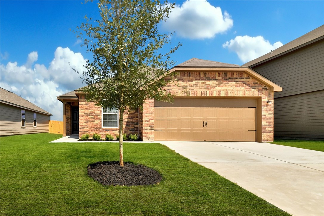 14005 Prospector Way Elgin, TX 78621 - Photo 1 of 1 a front view of a house with a yard and garage