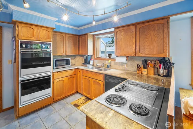 a kitchen with stainless steel appliances granite countertop a stove a sink and a microwave