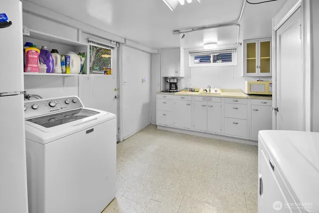 a utility room with cabinets washer and dryer