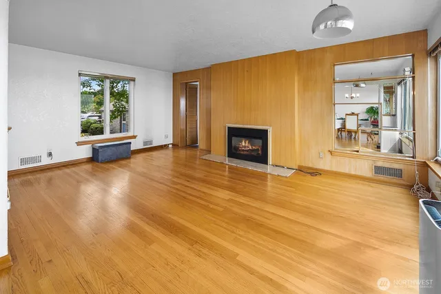 a view of empty room with a fireplace and wooden floor
