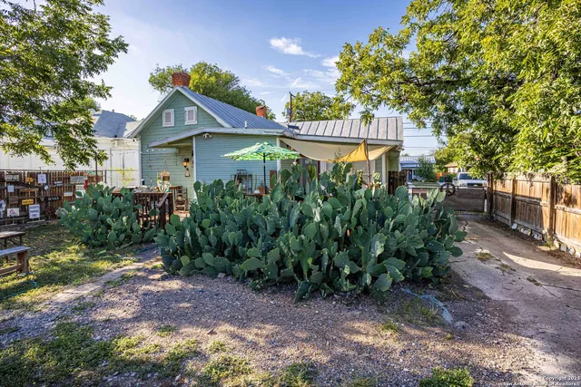 a view of a house with a yard and potted plants
