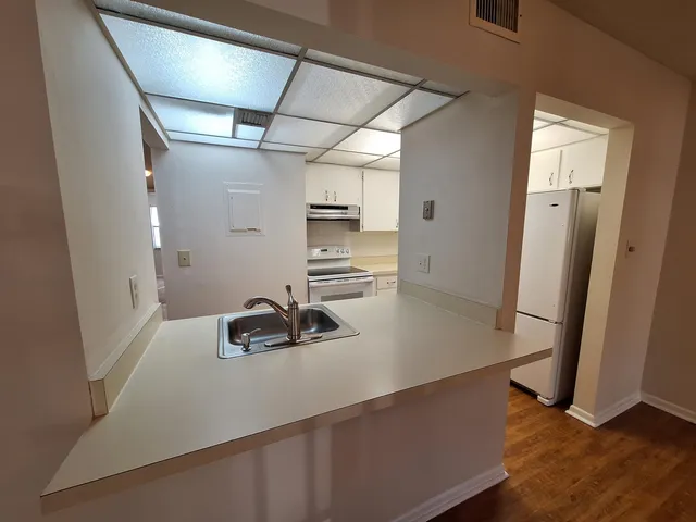 a kitchen with sink refrigerator and cabinets