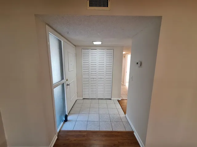 a view of hallway with a window and a kitchen