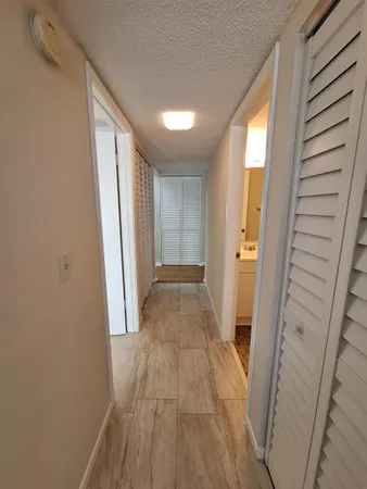 a view of a hallway with wooden floor and staircase