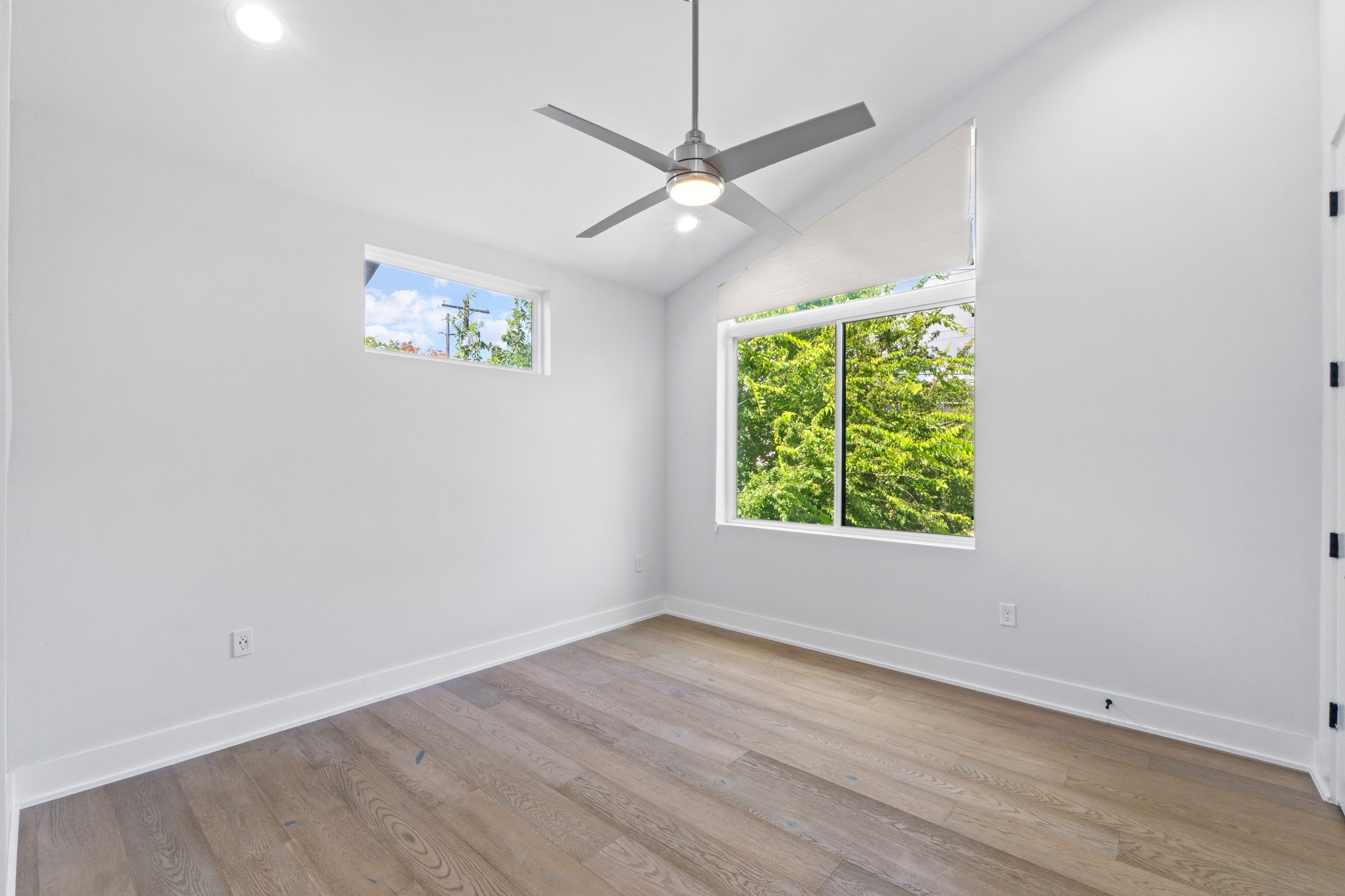 2007 Chestnut Avenue, Unit 1 Austin, TX 78722 - Photo 25 of 32 Wood flooring and generous windows enhance this inviting bedroom, offering a peaceful retreat.