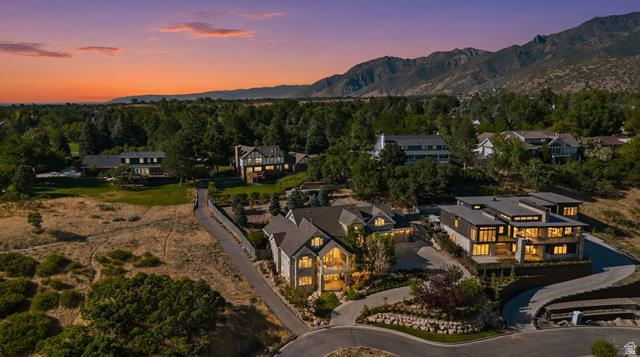 3 Carriagewood Cove, Unit 1088 Sandy, UT 84092 - Photo 66 of 79 Gated community featuring a paved street, mature landscaping, and mountain backdrop