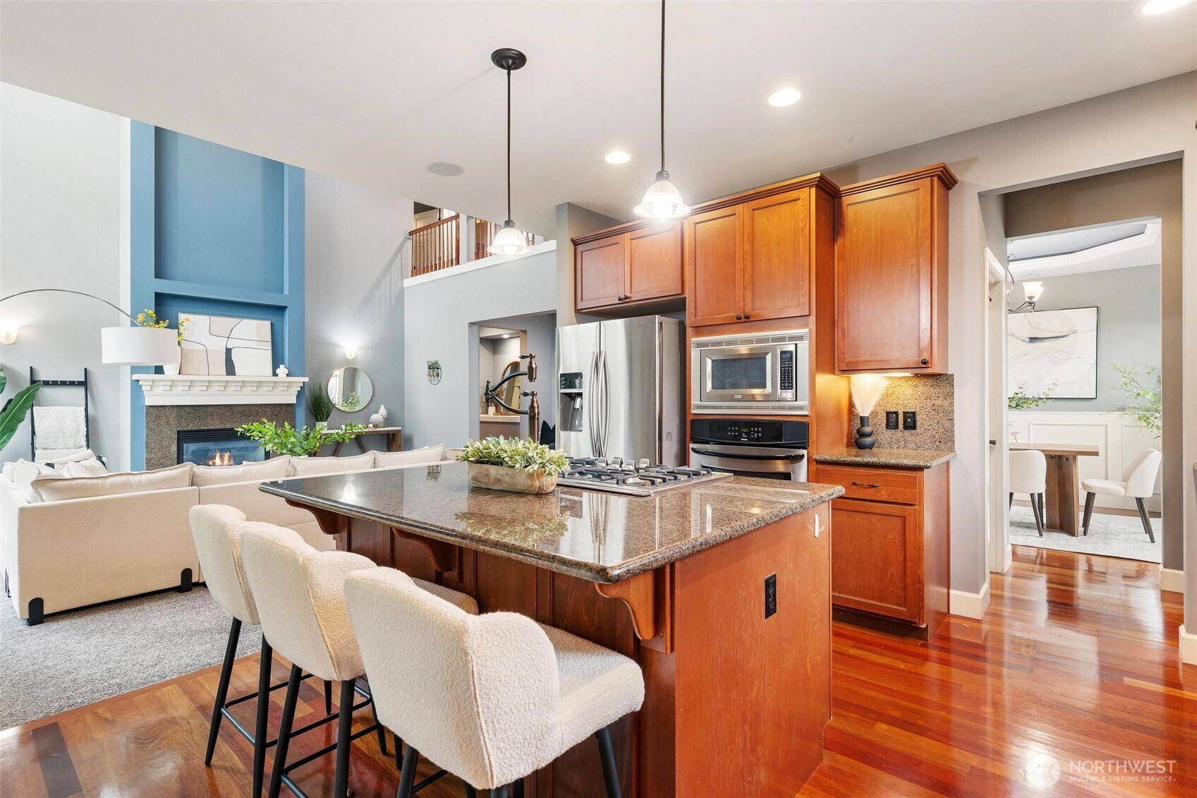 6743 Southeast 2nd Street Renton, WA 98059 - Photo 15 of 35 a kitchen with stainless steel appliances granite countertop a stove top oven a sink a dining table and chairs with wooden floor